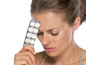 Portrait of thoughtful young woman with pills