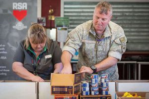Personnel from the RSA, New Zealand Defence Force, Countdown Supermarket and Mount Cook School packing goodies with a kiwi home into the RSA Christmas Gift Parcels destined for personnel deployed overseas at Christmas. Gaye Grosett, a Countdown Store Manager and LCC, Brigadier Mike Shapland packing goods into the boxes.